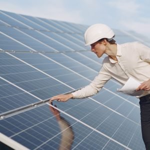 Portrait of client in white helmet at solar power station. Man in business suit.